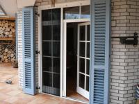 Pliszé szúnyogháló egy jó széles-, kétszárnyú teraszajtón, félrehúzva az ajtó nyitásánál